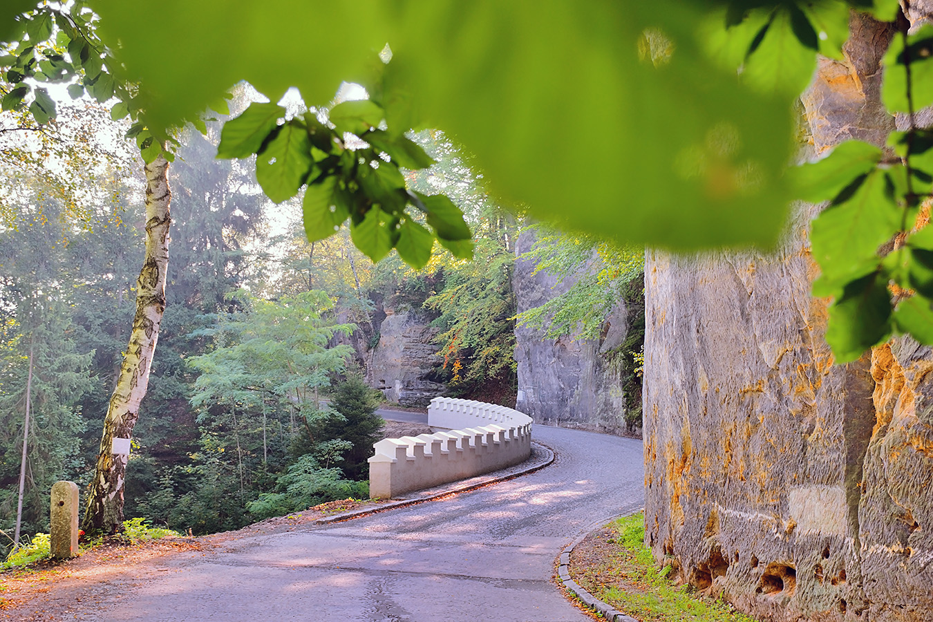 white historical crash barrier on asphalt way leading to Kokorin village in Kokorinsko area in autumnal czech republic